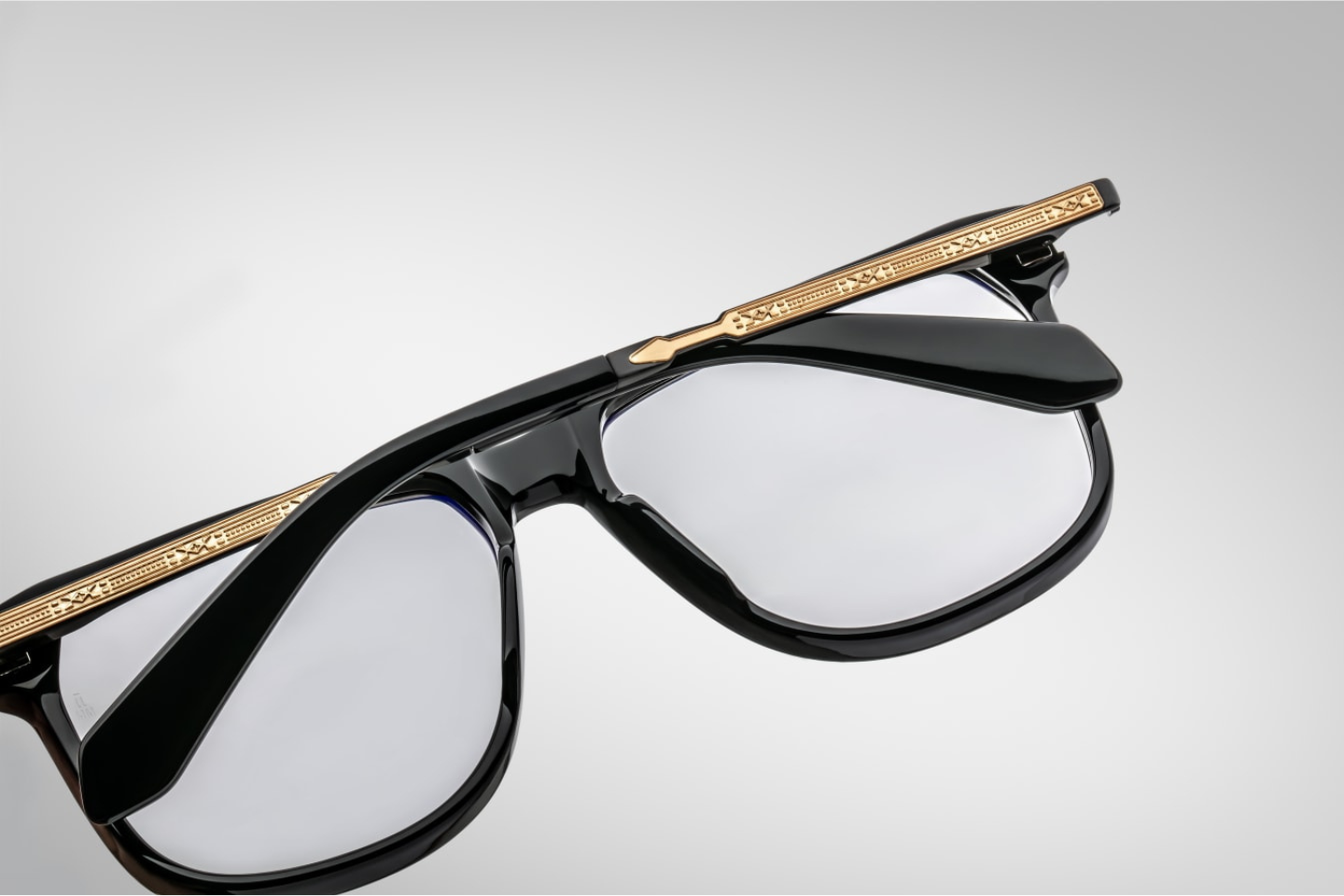 A back view of the 70's inspired boxy Kirkland frame by Jacques Marie mage with black cured acetate front, light grey lenses and dark gold 100% beta titanium temples with black accents. Available at WINK Optometrists