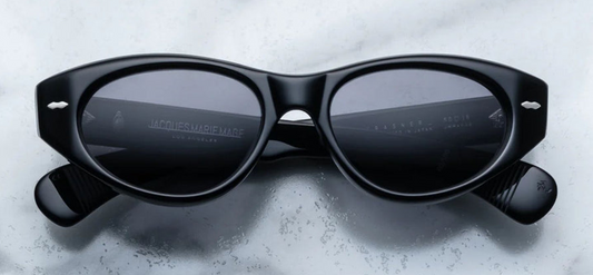 "Front view of Jacques Marie Mage Krasner sunglasses in Black, featuring a soft, mid-size cat-eye frame with an elegant oval lens shape. Crafted from 10mm black cured cellulose acetate, the frame showcases silver signature double-arrowhead front pins and a hidden wirecore, reflecting the frame's artisanal craftsmanship