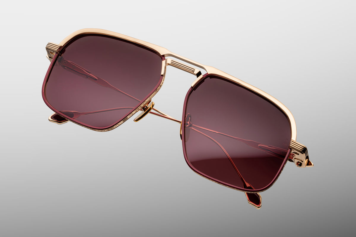 Top-down view of Jacques Marie Mage Labarge Champagne sunglasses. Highlights the thickness of the sculptural, light gold monoblock top bar and the precise curvature of the beta-titanium frame. The angle shows the seamless integration of the custom hinges and the straight, ornate temple arms extending back.