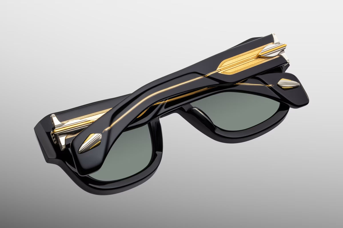 Full rear view of Jacques Marie Mage Conrad Noir sunglasses. The perspective highlights the inner profile of the substantial black acetate frames, structural gold nose pad arms with matching titanium pads, and the heavy-duty 9-barrel custom hinges securing the thick, transparent temples