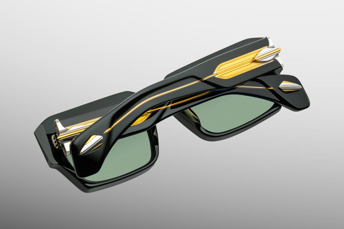 Rear view of Jacques Marie Mage Dakota Viper sunglasses with temples folded closed. The transparent portions of the folded arms overlap, clearly displaying the braided gold wirecores from behind. The chunky dark green frame profile and heavy silver hinges are showcased