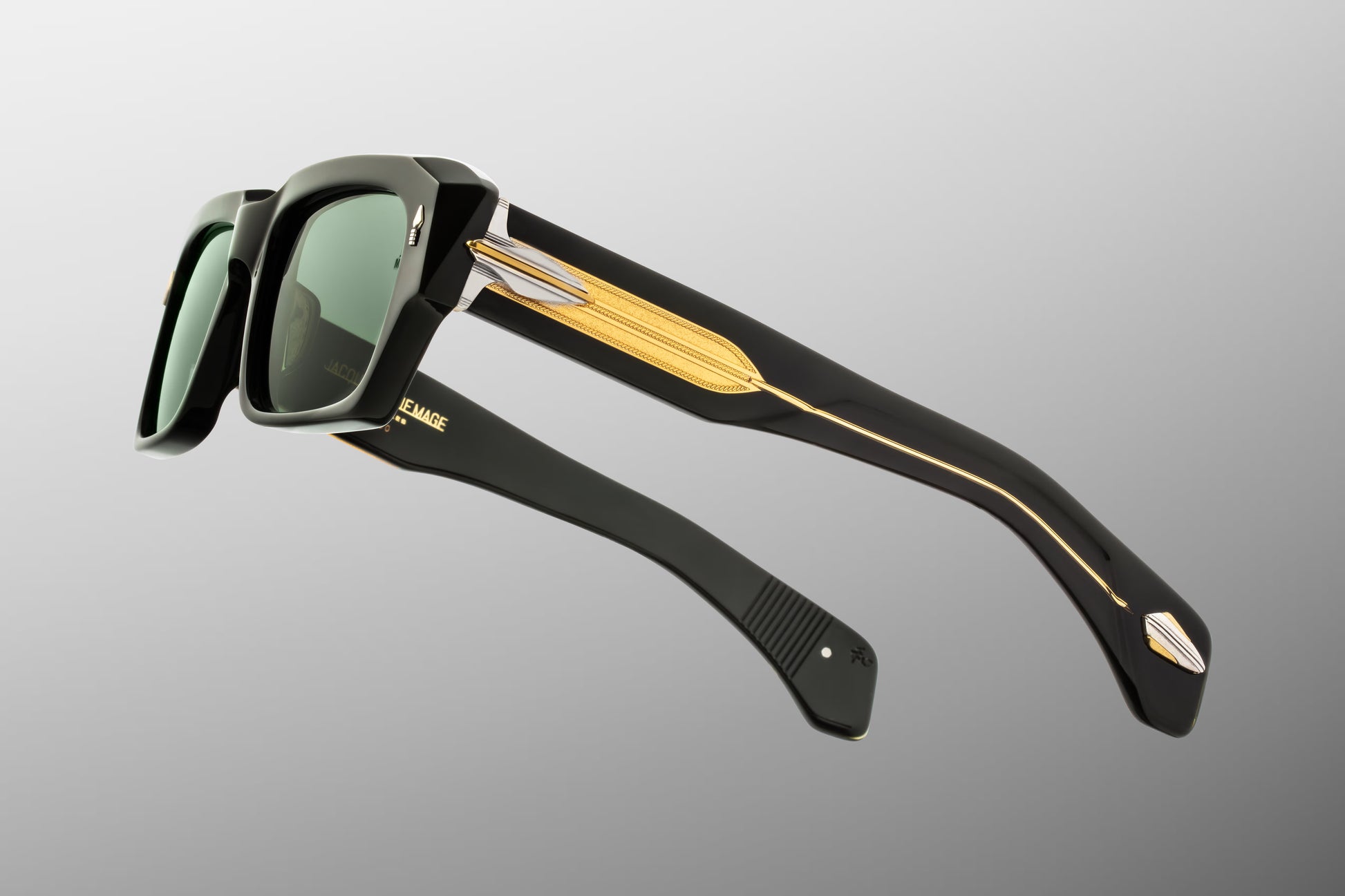 Side profile of JMM Dakota Viper sunglasses showcasing the detailed temple construction. The double-laminated dark green acetate temples transition to a clear layer, exposing an intricate, custom-braided gold "Lariat" wirecore. Silver and gold dual-tone arrowhead hardware secures the hinge