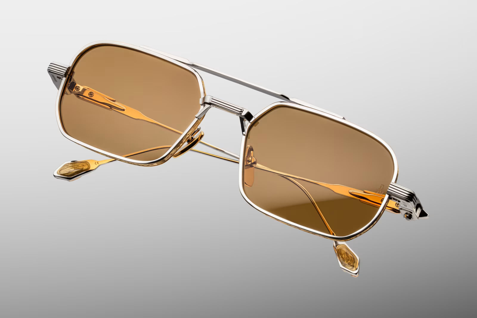 Top-down view of Jacques Marie Mage Deaver Electrum sunglasses. Emphasizes the clean, straight silhouette of the 90s-inspired silver palladium top bridge and frame. The view illustrates the precise alignment of the custom hinges and the ornate titanium temple arms extending bac