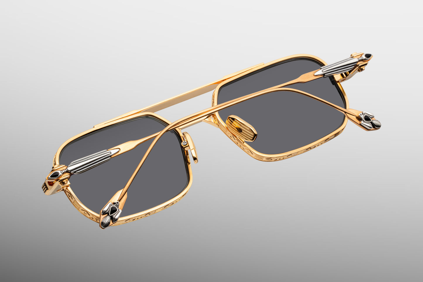 Rear view looking into the interior construction of Jacques Marie Mage Deaver Maxi frames. Shows the anti-reflective backside treatment of the grey lenses, dark gold titanium nose pads engraved with the JMM logo, and the internal design of the custom monoblock hinges