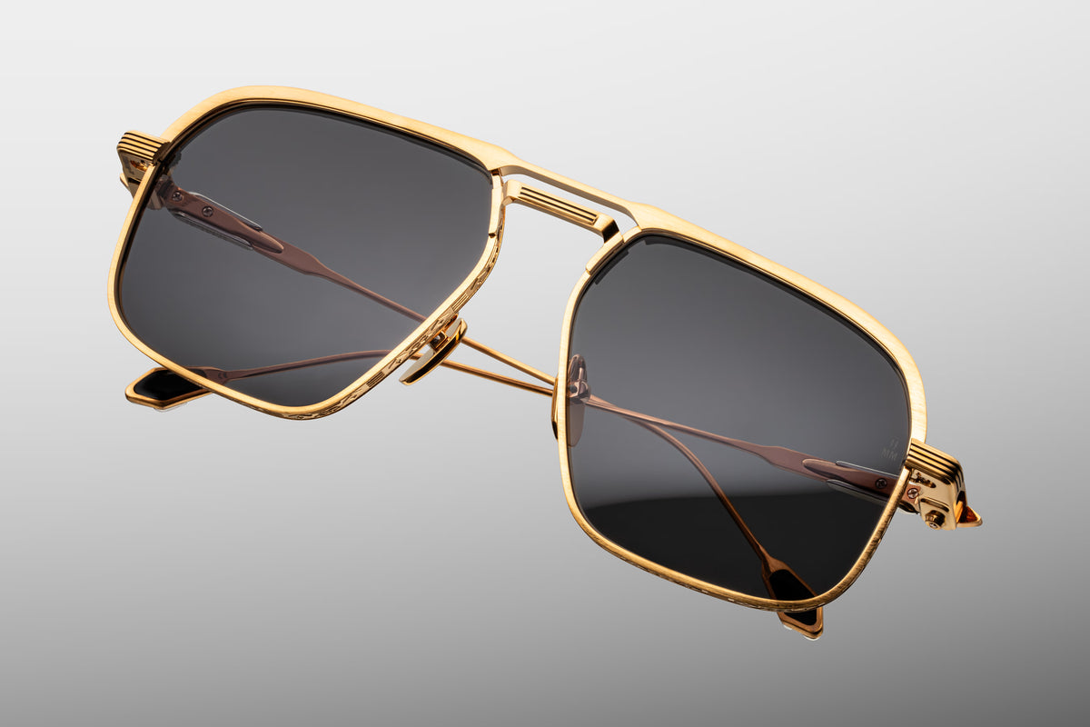  Top-down view of Jacques Marie Mage Labarge Maxi sunglasses, detailing the proportions of the bold dark gold monoblock top bar and double bridge. Shows the gentle curvature of the titanium frame and the straight alignment of the ornate temple arms extending backward