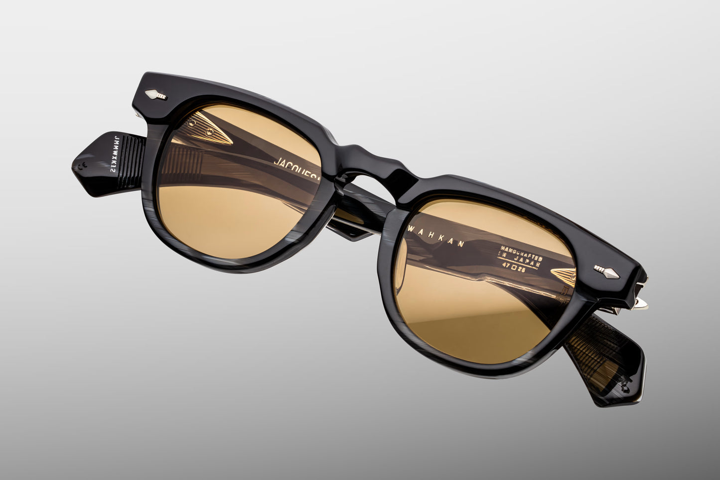 Top-down view of Jacques Marie Mage Wahkan Ridgeway sunglasses. Highlights the substantial 10mm thickness of the black horn acetate frame and the precise execution of the dimpled keyhole bridge. The view details the flush alignment of the silver palladium accents and the straight temple arms extending backward