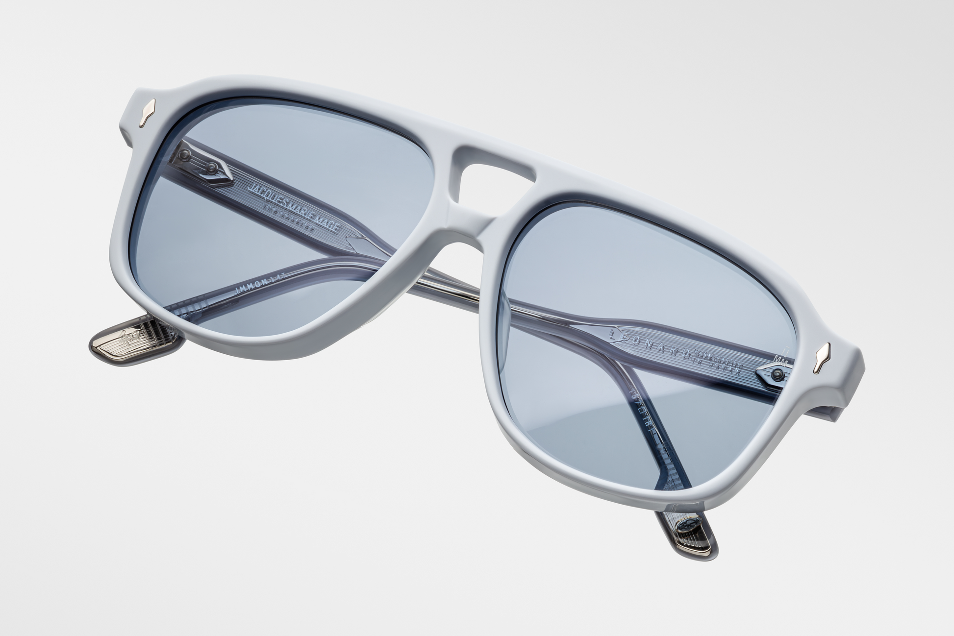 Top-down view of Jacques Marie Mage Leonard Suede sunglasses in Sky Suede: reveals the smooth, tactile matte exterior of the acetate frame and the curvature of the lenses. The double-bridge design is visible, showcasing the frame's structure.