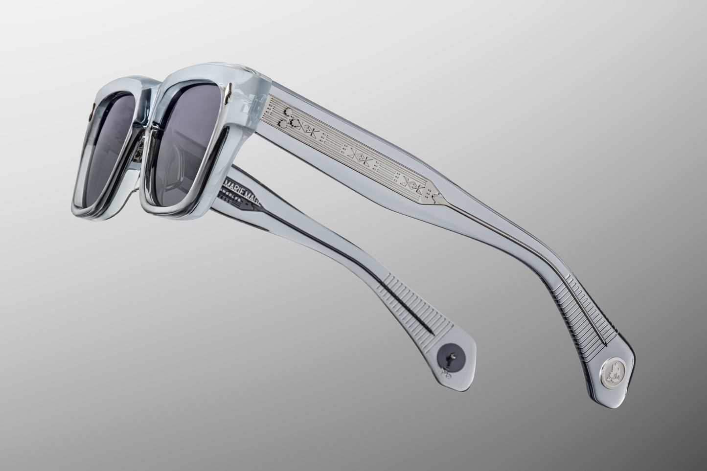 Side profile of Lupine Storm glasses showcasing custom 9-barrel hinges, hairline-engraved 'Spiketail' wirecores, and silver inner-temple markings