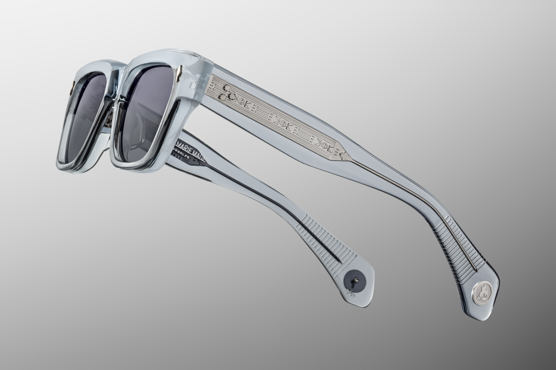 Side profile of Lupine Storm glasses showcasing custom 9-barrel hinges, hairline-engraved 'Spiketail' wirecores, and silver inner-temple markings