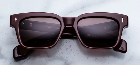 Front view of Jacques Marie Mage Molino Bordeaux Empire sunglasses. Displays a bold, 1960s-inspired rectangular 10mm block acetate frame in a high-gloss, deep wine-red burgundy, fitted with solid deep brown lenses and sterling silver arrowhead pins. Wink Optometrists