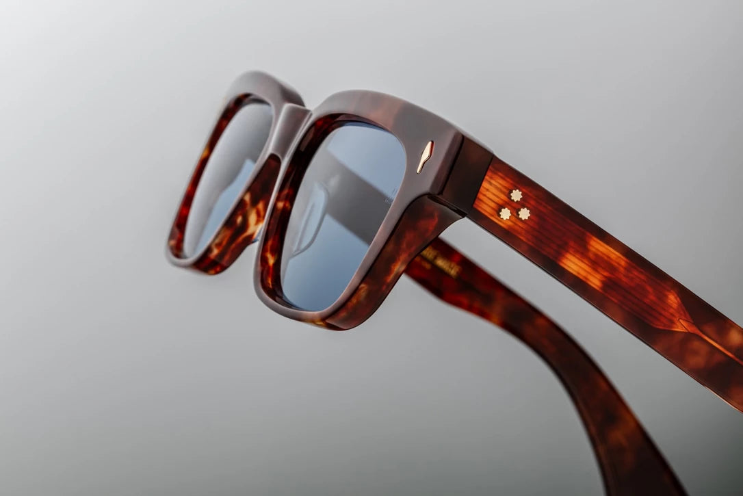 Side view of the JMM Molino 51 sunglasses temple arm, showcasing the polished Havana outer frame, custom double-laminated acetate temples, and light gold spur-shaped rivets.