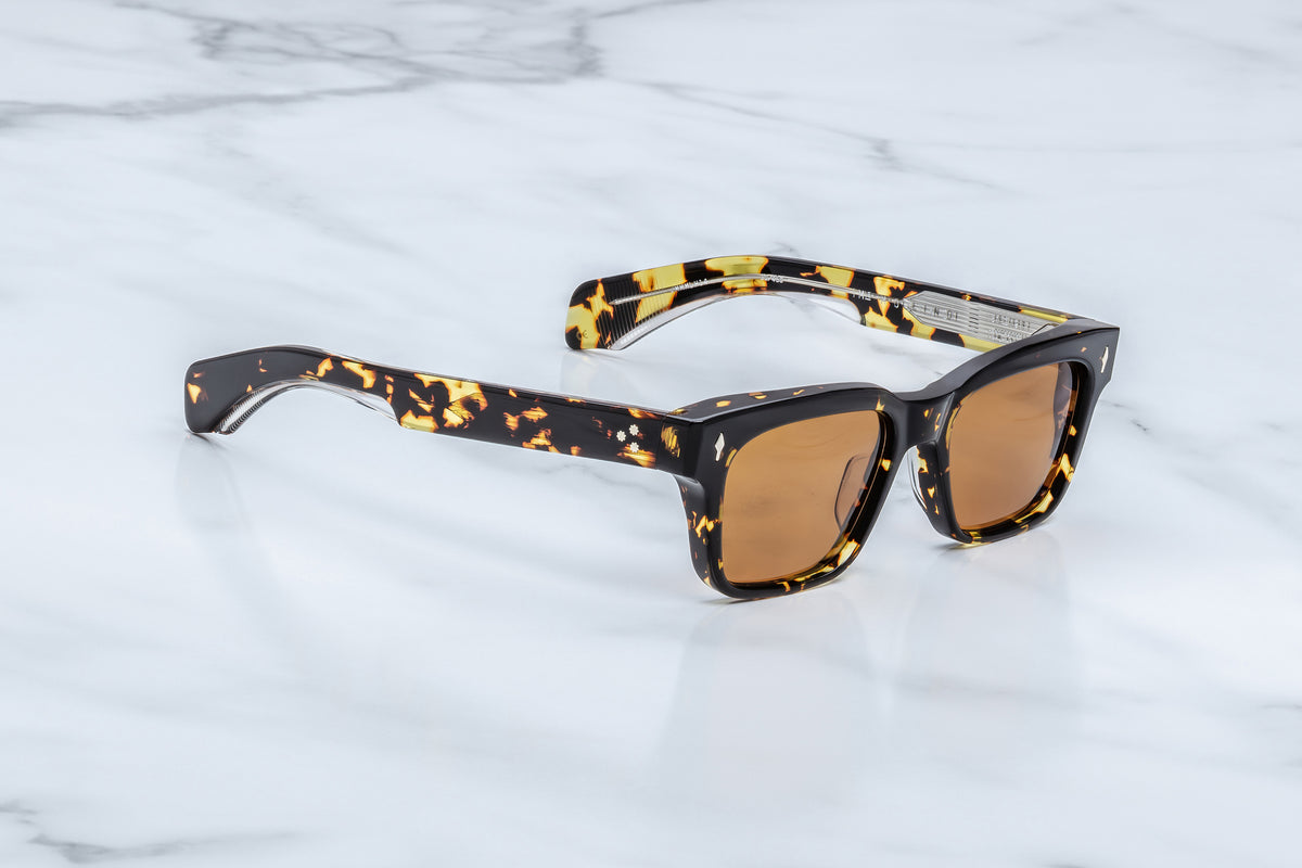 Three-quarter view of the Jacques Marie Mage Molino Tokyo sunglasses. This angle showcases the frame's heavy volume, subtle brow line beveling, and the dual-layered temples that reveal a silver filigree wire core beneath translucent clear interior acetate.