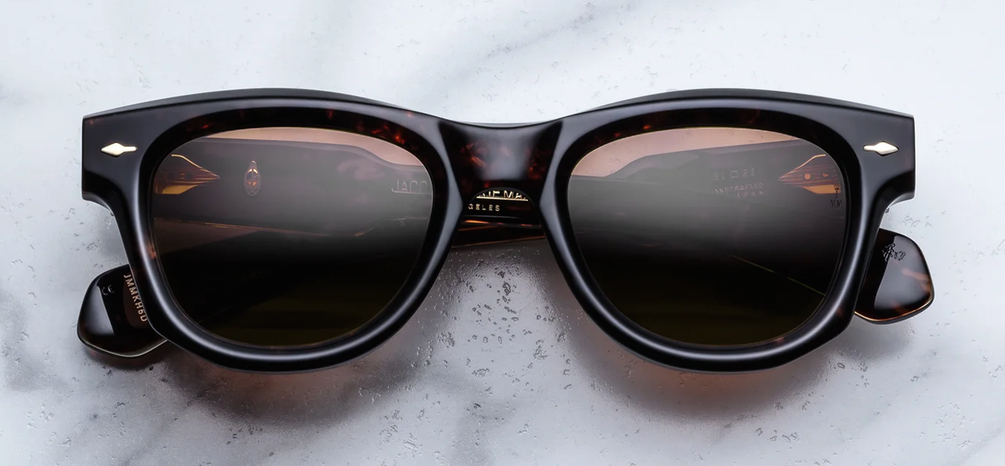 Front view of Jacques Marie Mage Kinshasa sunglasses in Agar tortoise shell acetate with round lenses, featuring signature dark gold arrowhead pins on the frame corners. Available at WINK Optometrists