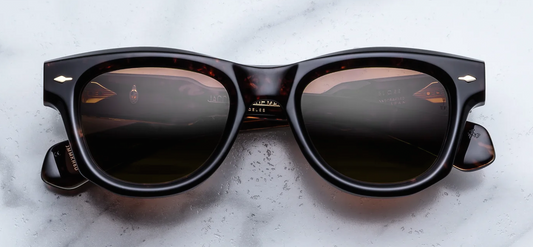 Front view of Jacques Marie Mage Kinshasa sunglasses in Agar tortoise shell acetate with round lenses, featuring signature dark gold arrowhead pins on the frame corners. Available at WINK Optometrists