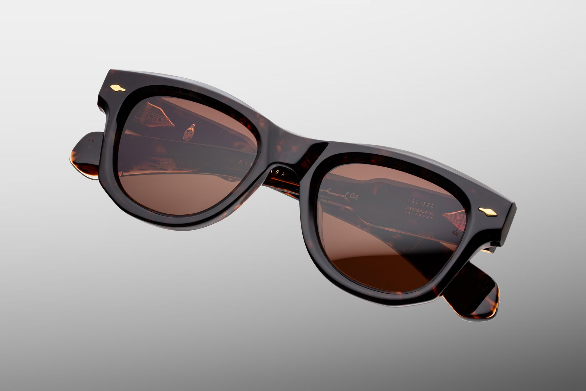 Top-down view of the JMM Kinshasa sunglasses, revealing the frame’s curved geometry, the substantial 10mm thick acetate brow line, and the heavy-duty 7-barrel block hinges