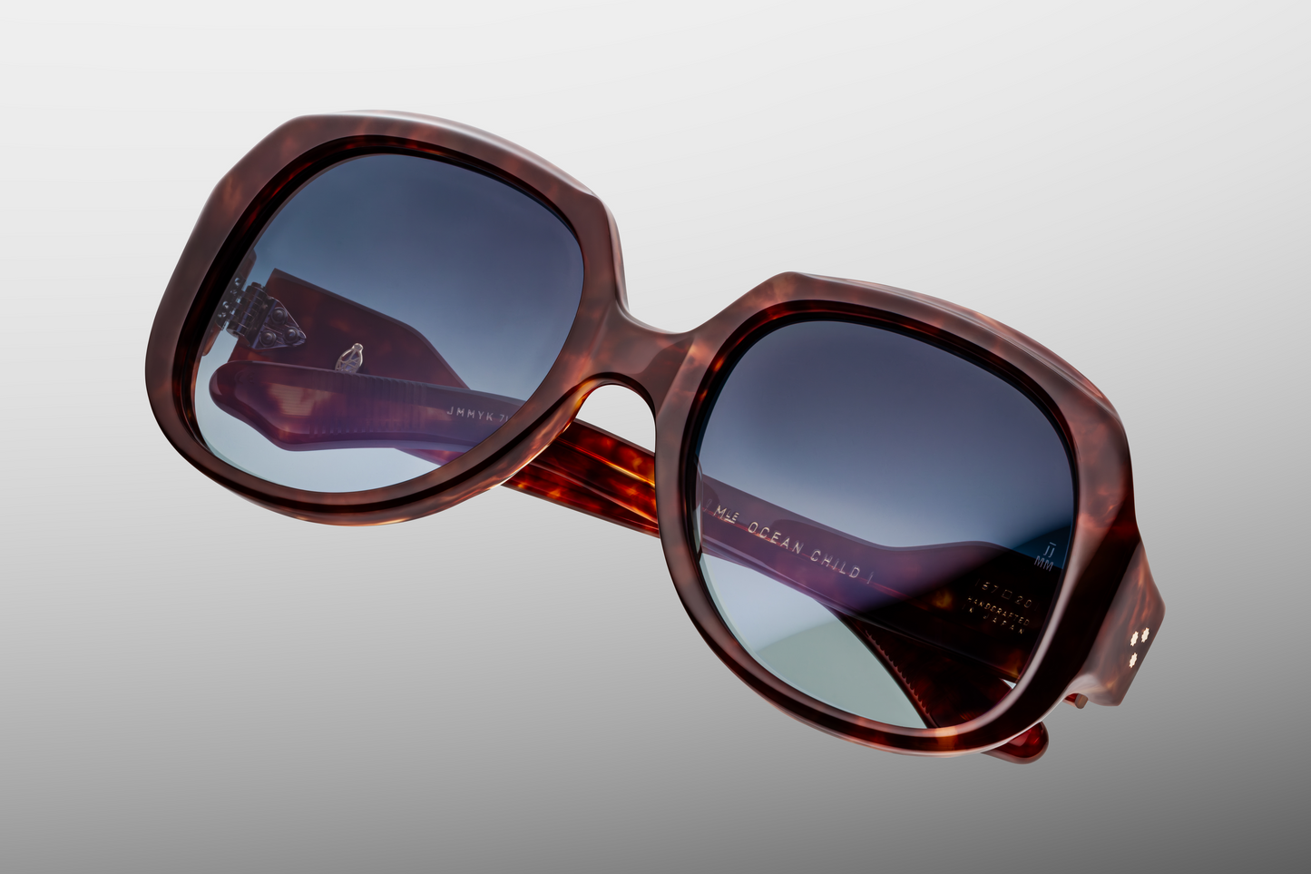 Top-down view of Ocean Child Breccia — broad 20 mm keyhole bridge, softly curved browline, and smooth bevelled edges in red-havana breccia acetate