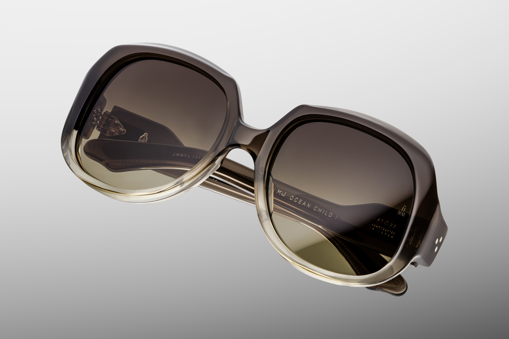 Top-down view of Ocean Child Smoke Fade — wide 20 mm keyhole bridge, softly sloping browline and smooth edges in gray-fade acetate.