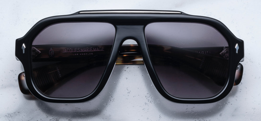 A pair of Jacques Marie Mage Octavian sunglasses with a black frame, titanium bar accent on the top brow, and black gradient lenses.
