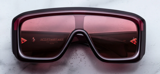 Jacques Marie Mage Pausa Amarena sunglasses front view, bold red acetate wraparound frame with shield lens and gold arrowhead rivets
Front view of JMM Pausa Amarena sunglasses, oversized rectangular shield frame in deep red acetate with gradient lenses