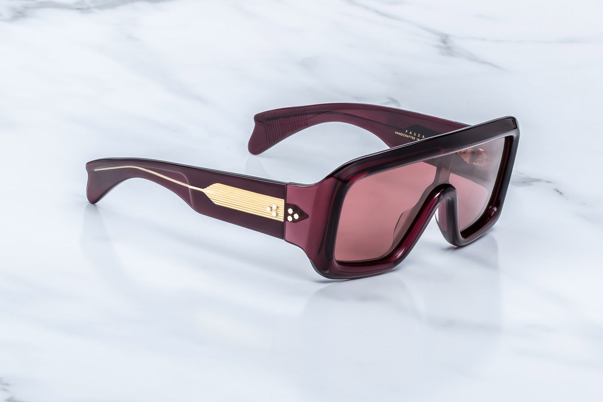 Jacques Marie Mage Pausa Amarena side view showing thick red acetate temples, exposed gold wire core and wide wraparound fit
Side profile of JMM Pausa Amarena sunglasses highlighting sculptural temples, gold hardware and shield lens design