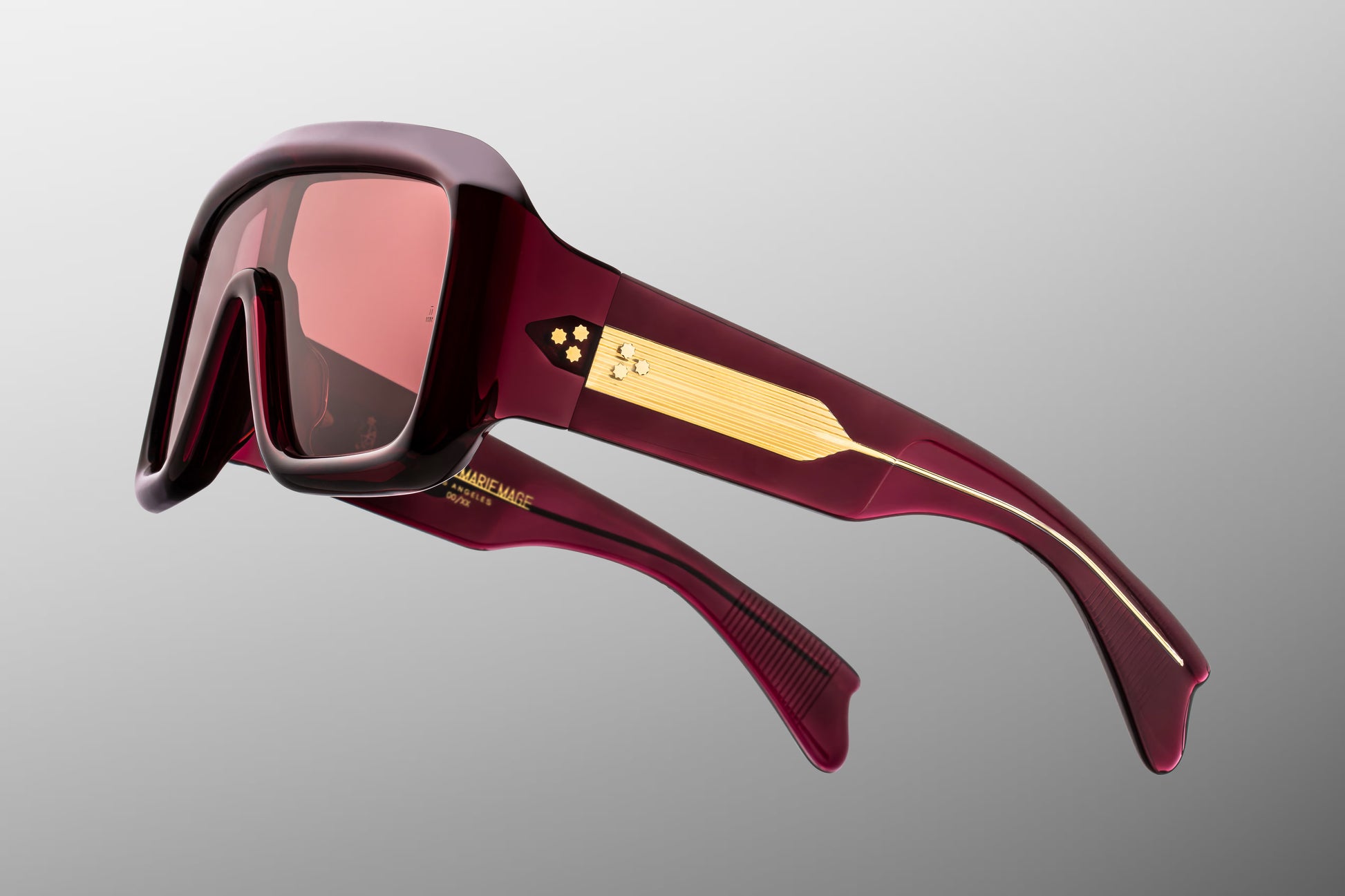 Close-up side detail of Jacques Marie Mage Pausa Amarena showing engraved gold wire core, hinge construction and layered acetate temples
Macro side view of JMM Pausa Amarena sunglasses highlighting premium hardware and temple detailing