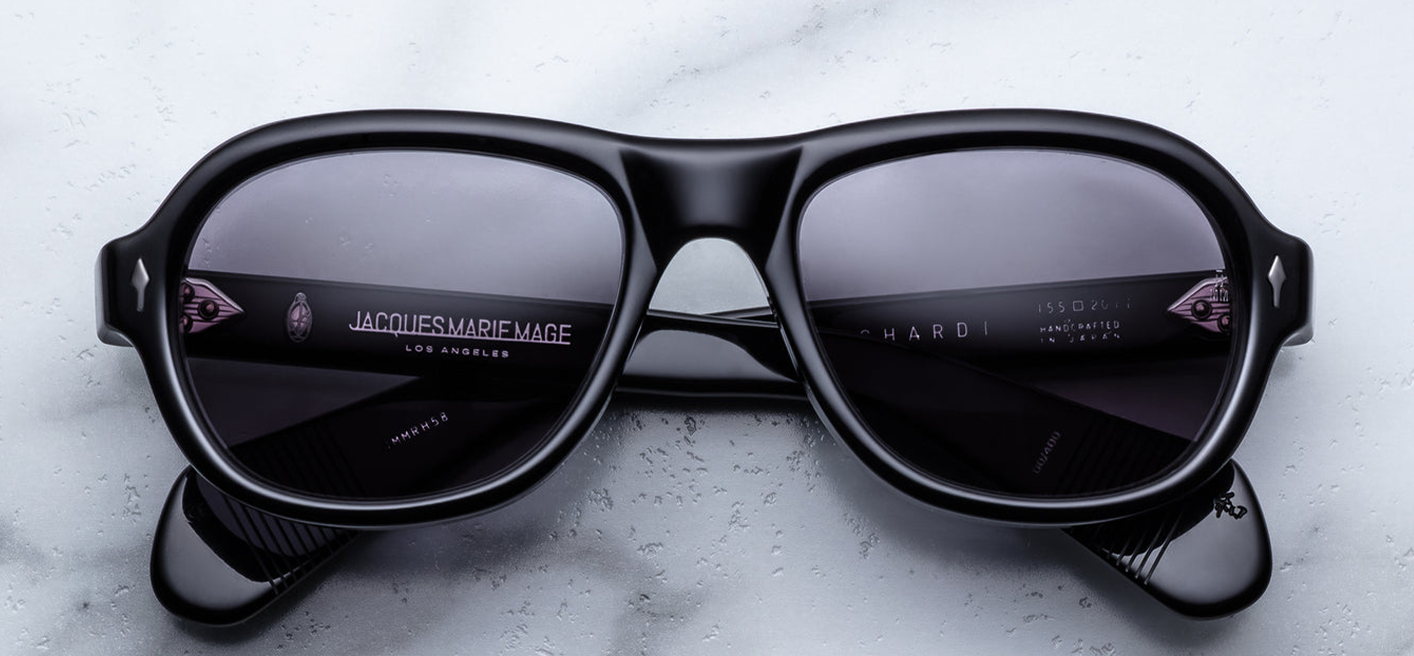 A pair of Jacques Marie Mage Richard sunglasses in Raven: glossy black 10 mm cured cellulose acetate frame with a modern aviator-oval shape, charcoal CR39 lenses, and double-arrowhead gunmetal front pins.