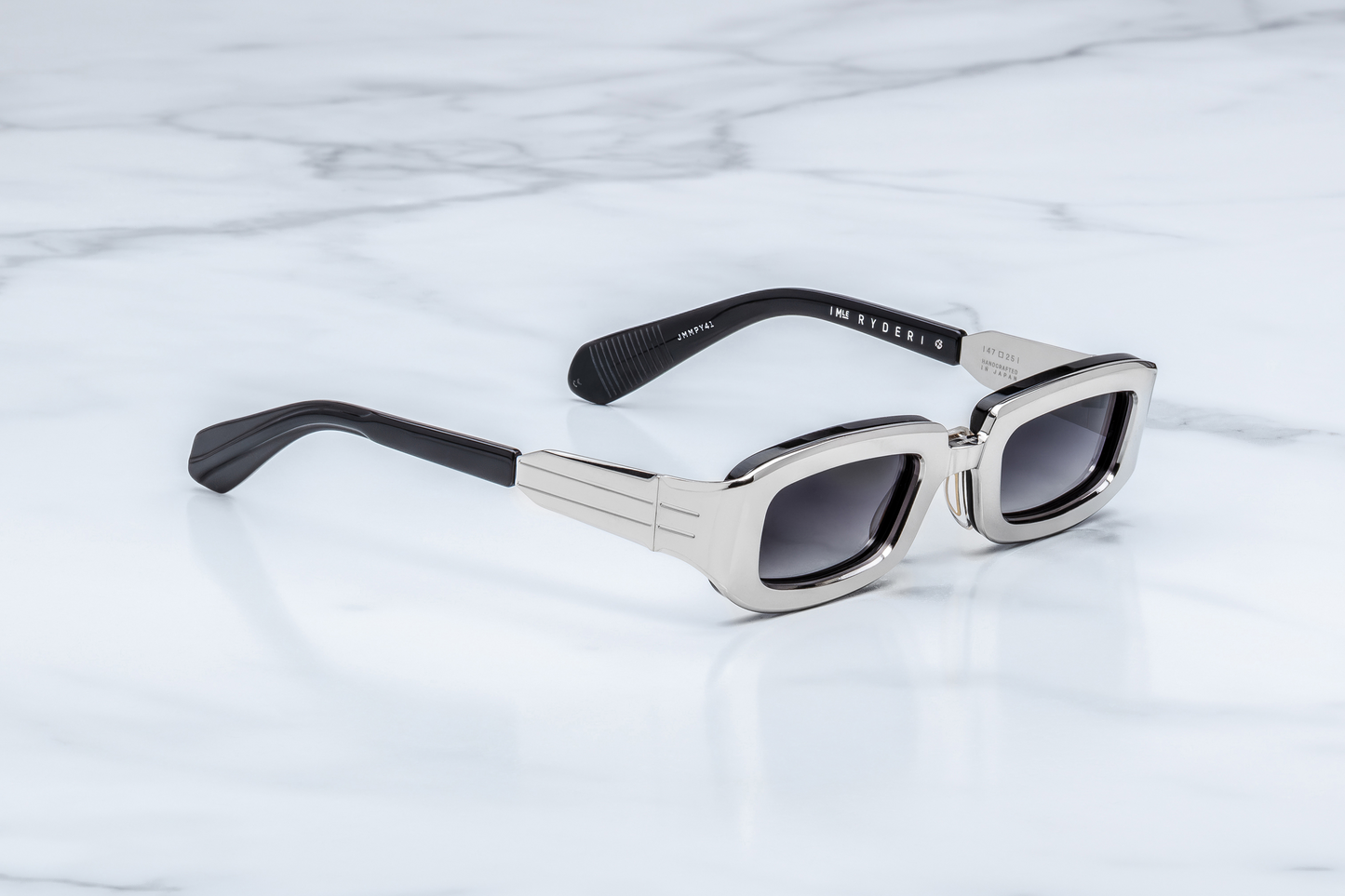 Jacques Marie Mage Ryder Silver sunglasses three quarter angle showing premium silver titanium aviator frame, sculpted bridge and tinted lenses – available at Wink Optometrists