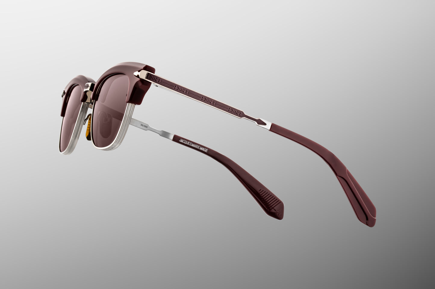 Jacques Marie Mage Sartre Bordeaux sunglasses temple detail with engraved titanium arms, signature arrowhead hinge, and burgundy acetate tips