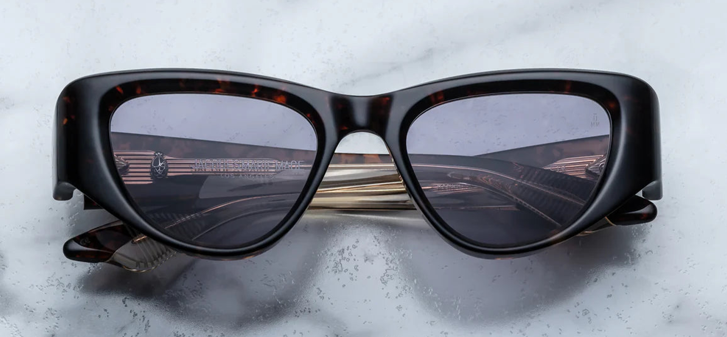 Jacques Marie Mage Seymour Beau — medium-sized cat-eye frame in warm havana acetate with subtle tortoise flecks, light gold metal arrowhead detailing, and Nimbus purple lenses