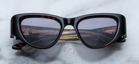 Jacques Marie Mage Seymour Beau — medium-sized cat-eye frame in warm havana acetate with subtle tortoise flecks, light gold metal arrowhead detailing, and Nimbus purple lenses