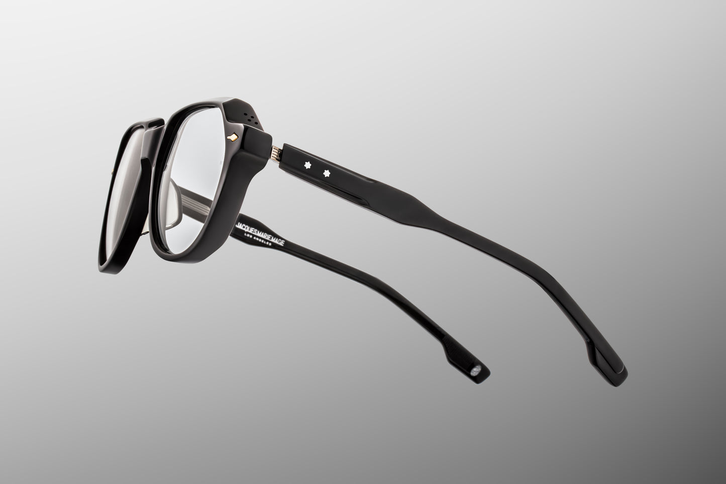 Close-up side detail of Jacques Marie Mage Shozo black frame showing engraved wire core, hinge construction and layered acetate temples
Macro side view of JMM Shozo black eyeglasses highlighting premium hardware and temple structure