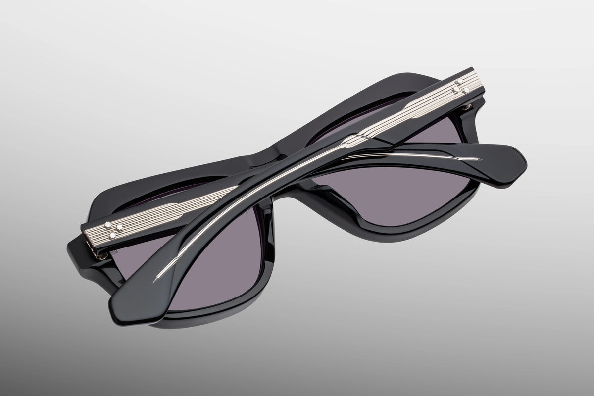 Inner rear view of Jacques Marie Mage Tamerlis Bloodstone sunglasses, detailing the heavy-duty 7-barrel hinge with silver spur-shaped rivets, the rich crimson-burgundy interior temple acetate, and the limited-production batch number foil-stamped in silver.
