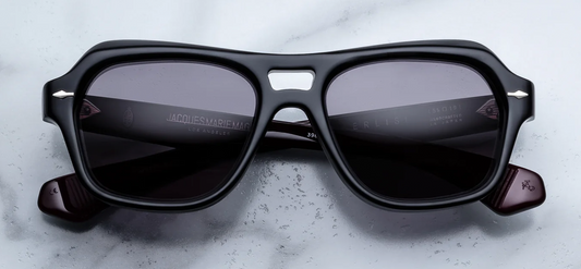 Front view of Jacques Marie Mage Tamerlis Bloodstone sunglasses. Displays an aggressive, late-1990s-inspired modified square frame in polished 10mm black block acetate, showcasing a distinct double bridge, heavily beveled winged brow line, deep jet-black lenses, and sterling silver arrowhead pins.