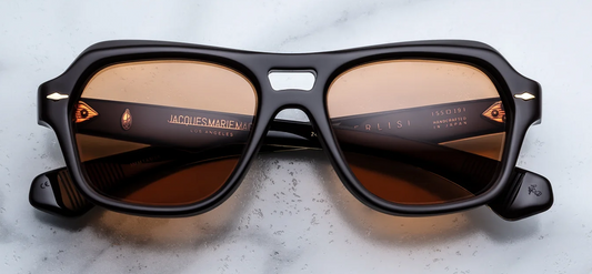 Front view of Jacques Marie Mage Tamerlis Walnut sunglasses. Features a bold, late-1990s-inspired modified square frame in rich polished brown acetate, featuring a dramatic double bridge, a beveled brow line, and solid orange lenses with dark gold arrowhead front pins.