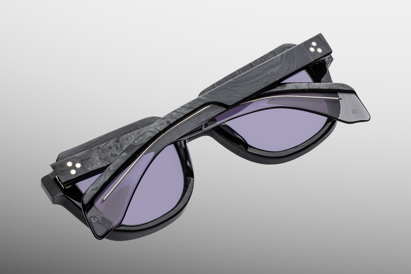 Interior of Taos Ebony — Nimbus grey Armorlite lenses framed by charcoal burlwood acetate, with silver arrowhead pins visible from the inside.