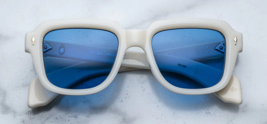 Jacques Marie Mage Taos in Mykonos sunglasses, bold, rectangular 10 mm white cured acetate frames evoking Mykonos’ architecture. They feature exposed silver wire‑core temples threaded with tribal-engraved detailing, vintage-style 4-base blue gradient CR39 lenses with backside anti‑reflective coating, and full UV protection. Inspired by Dennis Hopper’s eyewear in Easy Rider, this is a limited edition of 150 pieces at WINK Optometrists