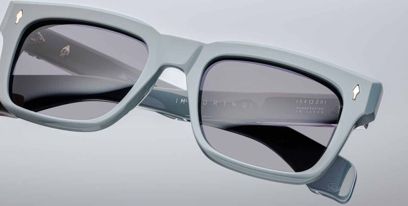 Close-up of the Molino Tiger hinge — silver tension-secured 7-barrel hinge with spur-shaped rivets on glossy blue acetate