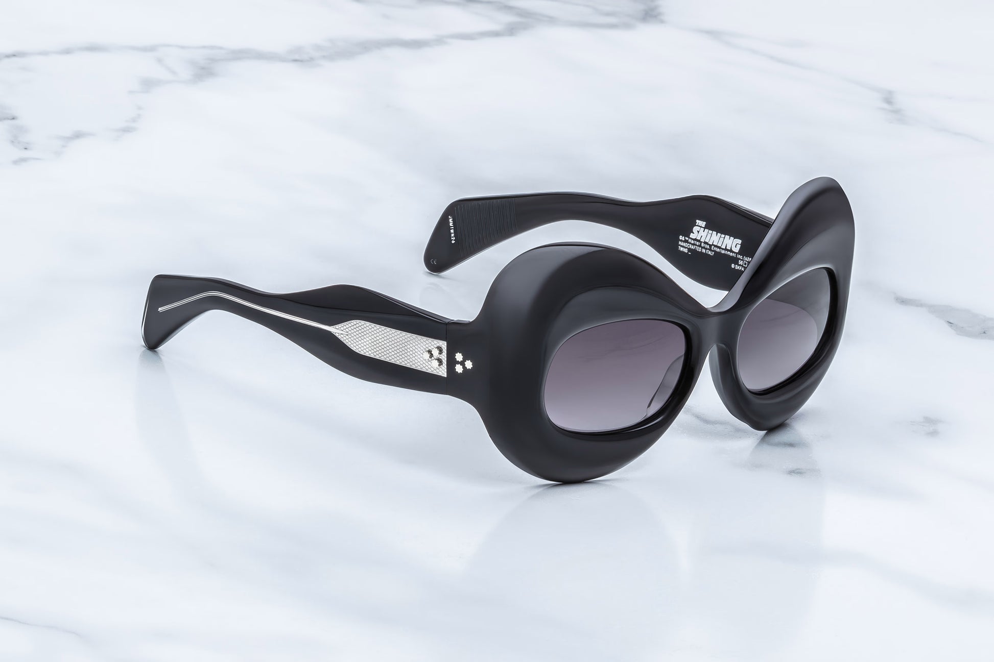 Jacques Marie Mage Twins Shadow side view showing thick black acetate temples, curved profile and exposed silver wirecore
Side profile of JMM Kubrick Twins Shadow sunglasses highlighting oversized butterfly shape and sculpted temples