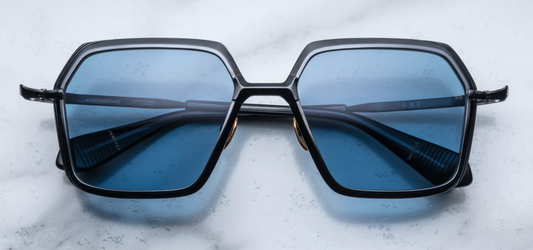JMM Ugo Black — sculpted hexagonal black beta‑titanium frame with azure-blue lenses and angular sculpted volumes.