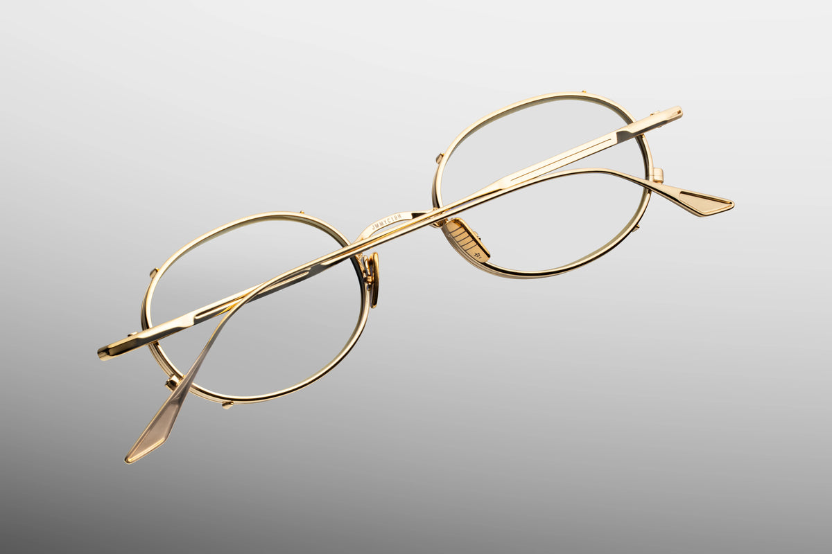 Detailed close-up view from behind the hinge of the JMM Violet RX frames. The shot showcases the precision-engineered, custom monoblock metal hinge connecting the chassis to the slim arm. Custom gold titanium nose pads are visible alongside small, clean branding details engraved on the inside frame