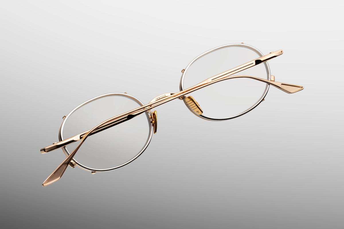 Detailed close-up view from behind the hinge of the JMM Violet RX Darjeeling frame. The shot reveals the precision-engineered, custom monoblock metal hinge connecting the slim gold temple arm to the chassis. Custom gold titanium nose pads are visible alongside clean, laser-etched branding and limited-edition numbering inside the rim