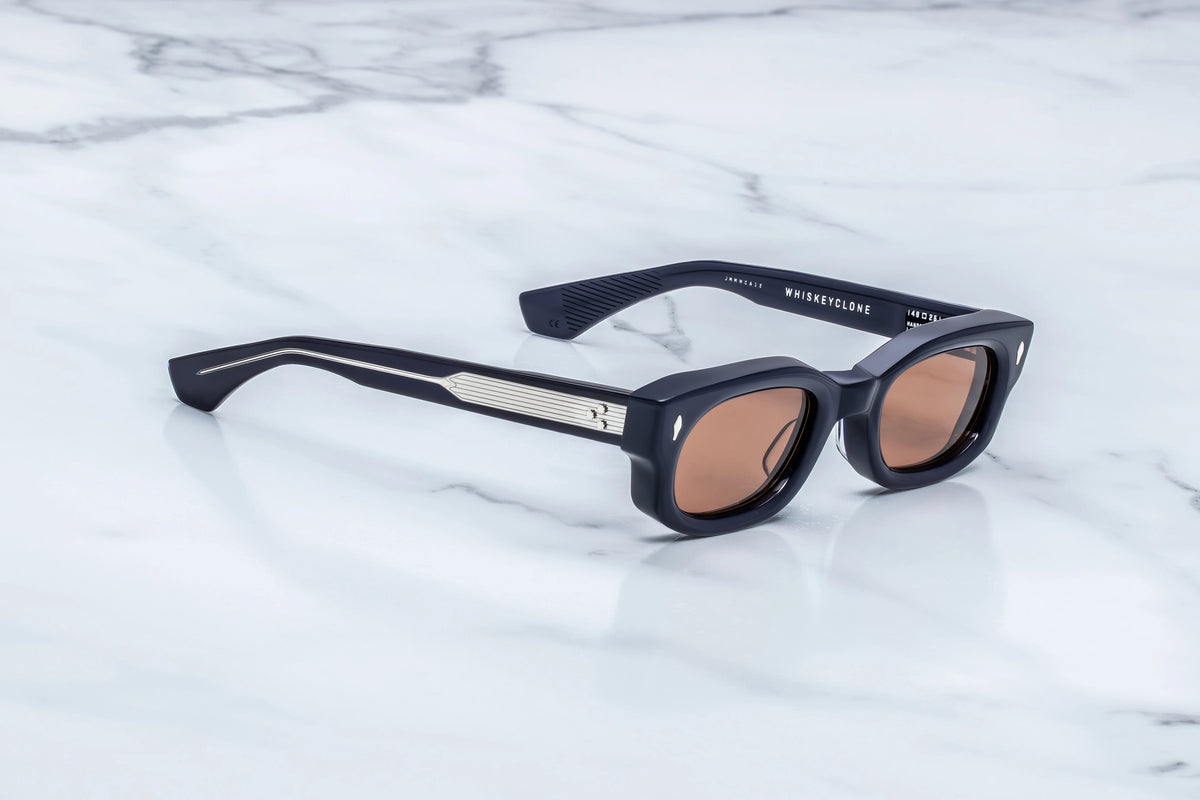 Side profile view of the Jacques Marie Mage Whiskeyclone Minuit sunglasses. The substantial, custom triple-laminated acetate temples stretch straight back. The highly polished, glossy deep navy finish subtly reveals its blue undertones where the translucent material thins toward the sculpted ear pieces