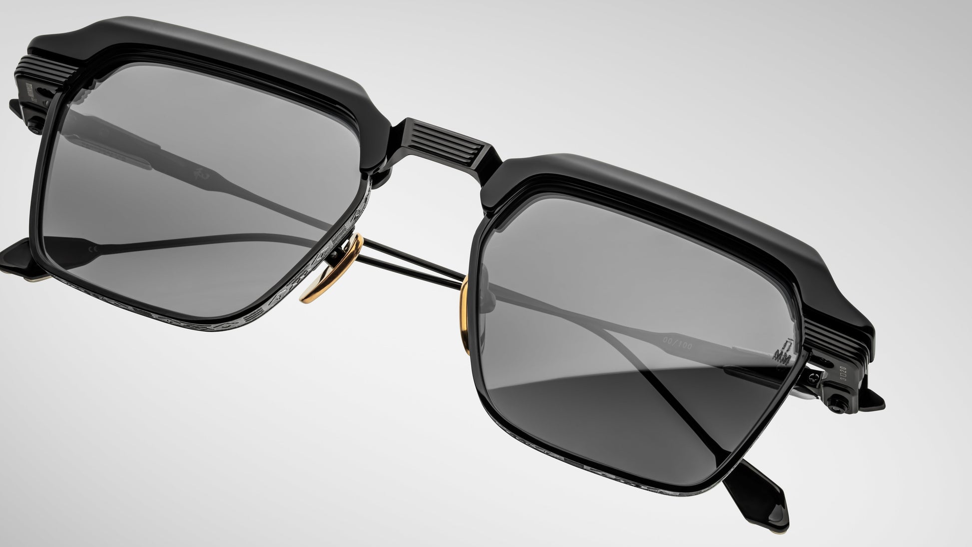 Black sunglasses with a futuristic design on a light gray background