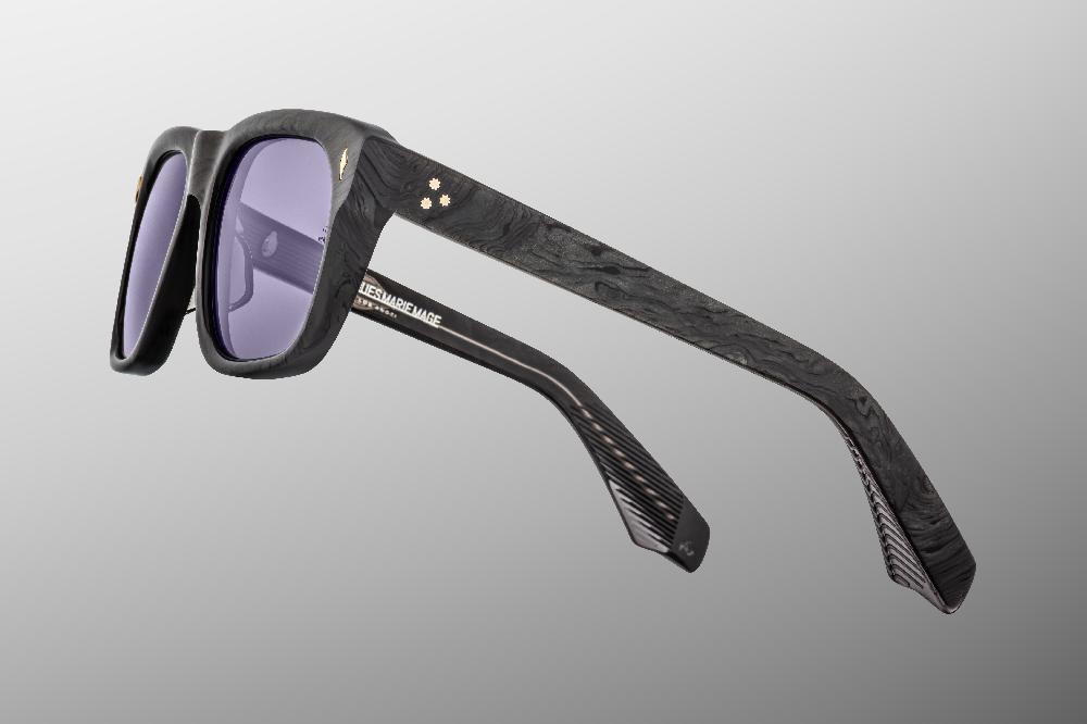 Three-quarter angle of the JMM Yves Ebony — showing the thick 10 mm plant-based acetate frame, top edge tapering toward the temples, and custom 7-barrel hinge