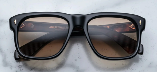 Black sunglasses with reflective lenses on a textured surface