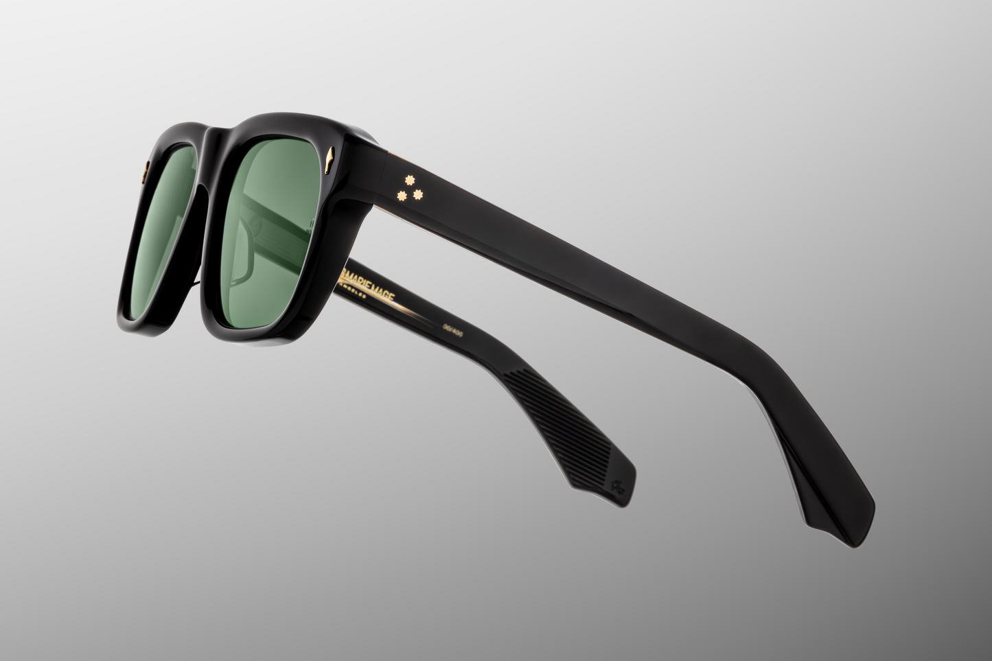 Side profile of Yves Venom — double-laminated black acetate temples with a dark-gold arrowhead front pin and exposed dark-gold wire-core inside the temple