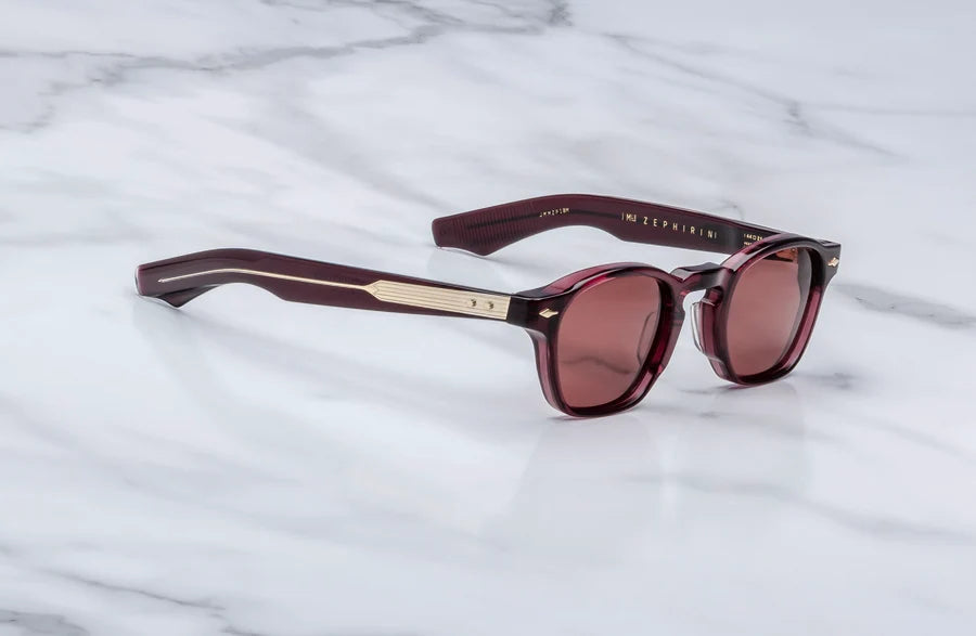 Three-quarter angled studio shot of the JMM Zephirin Amarena sunglasses, highlighting the structural beveling of the thick 10mm red acetate block frame and its classic keyhole bridge