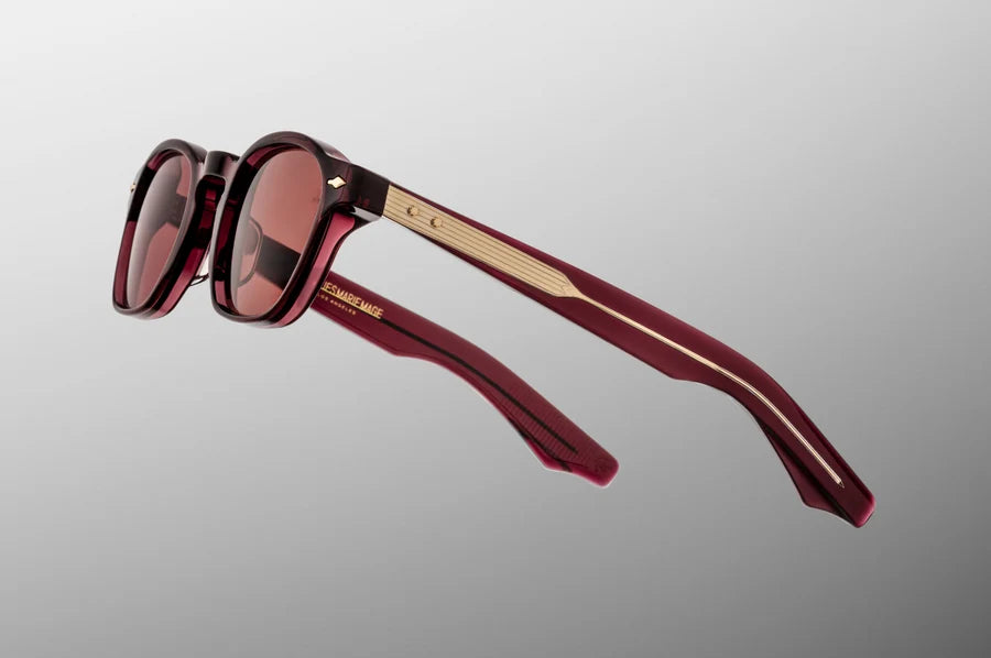 Side view of the JMM Zephirin Bordeaux Empire sunglasses temple arm, showcasing the glossy burgundy-red double-laminated acetate construction and the signature flush gold spur-shaped rivets