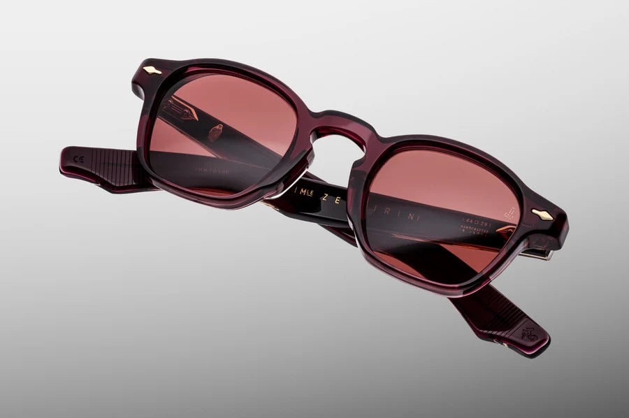 Three-quarter angled studio shot of the JMM Zephirin Amarena sunglasses, highlighting the structural beveling of the thick 10mm red acetate block frame and its classic keyhole bridge