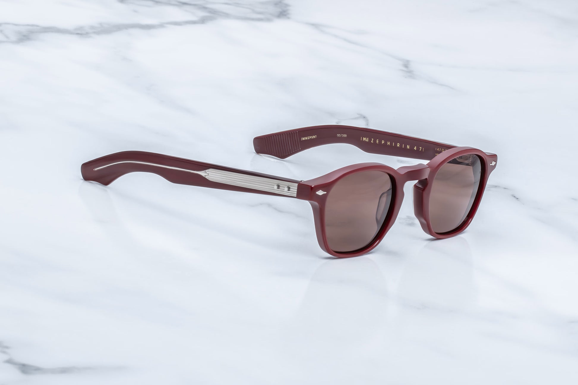  Three-quarter angled view of the JMM Zephirin Bordeaux Empire sunglasses, highlighting the retro keyhole bridge, distinct sculptural 10mm frame thickness, and deep wine-red acetate tones.